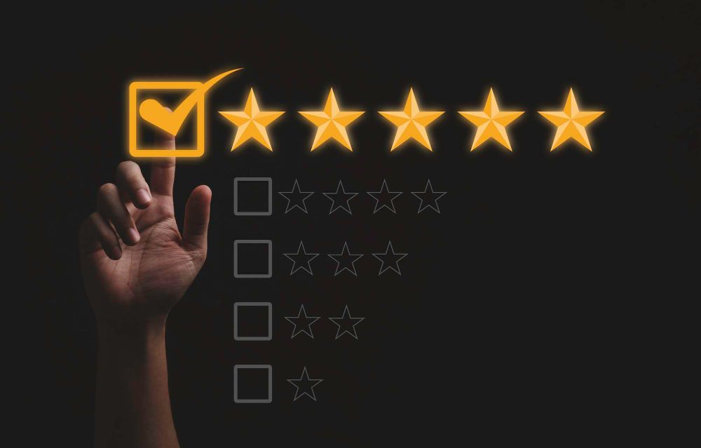 Hand selecting a five-star rating in a customer review interface