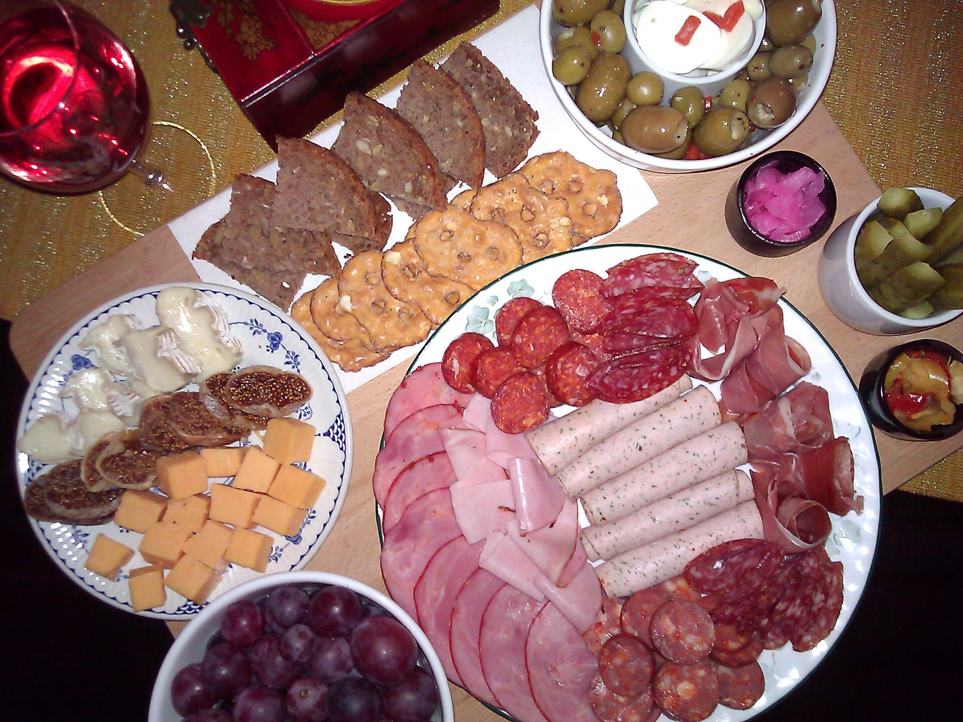 A wooden charcuterie board holding fruit and pickled vegetables, illustrating why dimensions, finish, and intended food use must be specified.