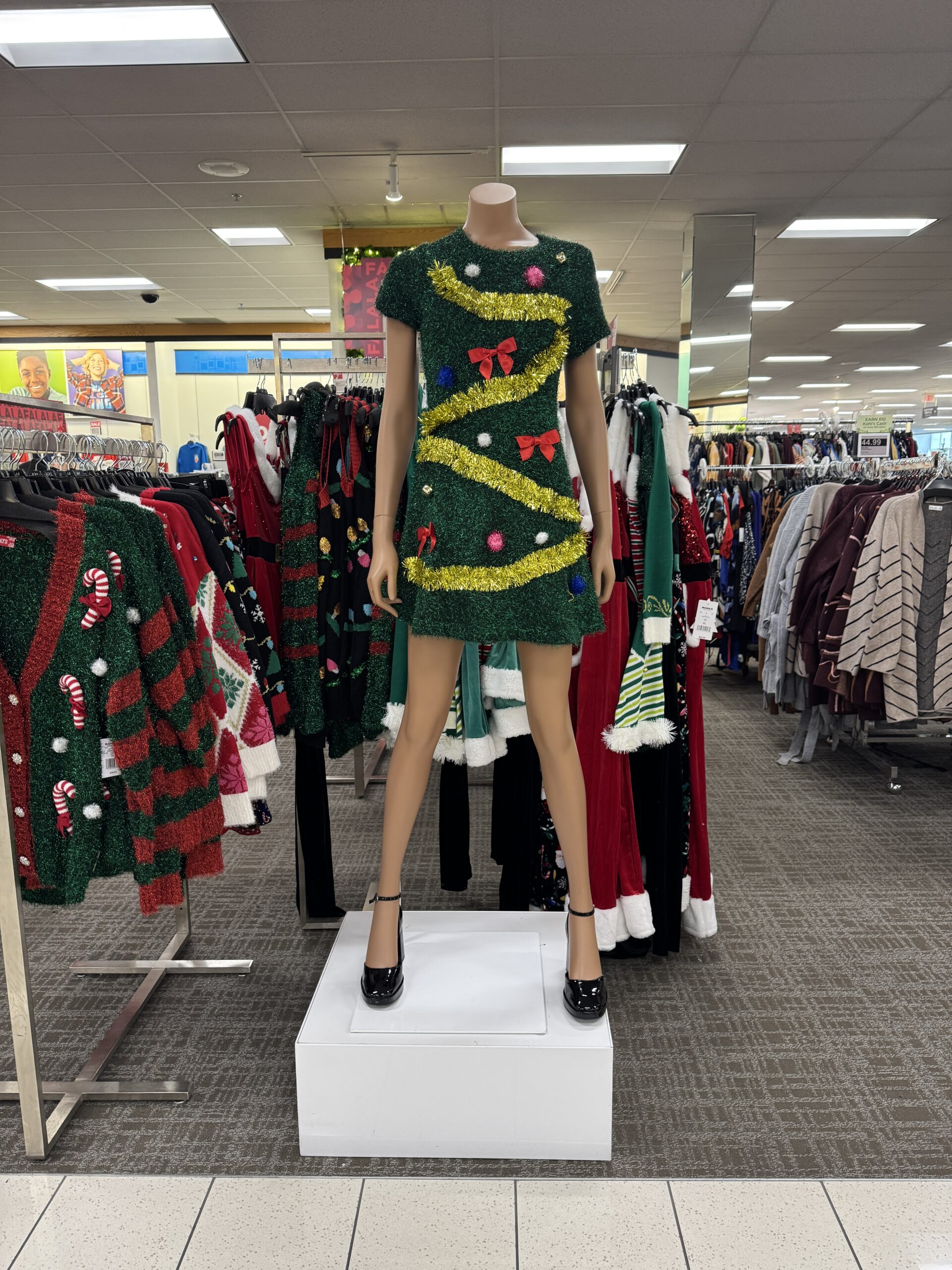 Green Christmas-tree dress displayed on a mannequin in a clothing store