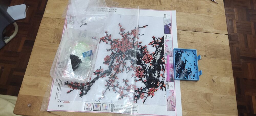 An unfinished diamond painting showing the small resin drills placed across a printed canvas