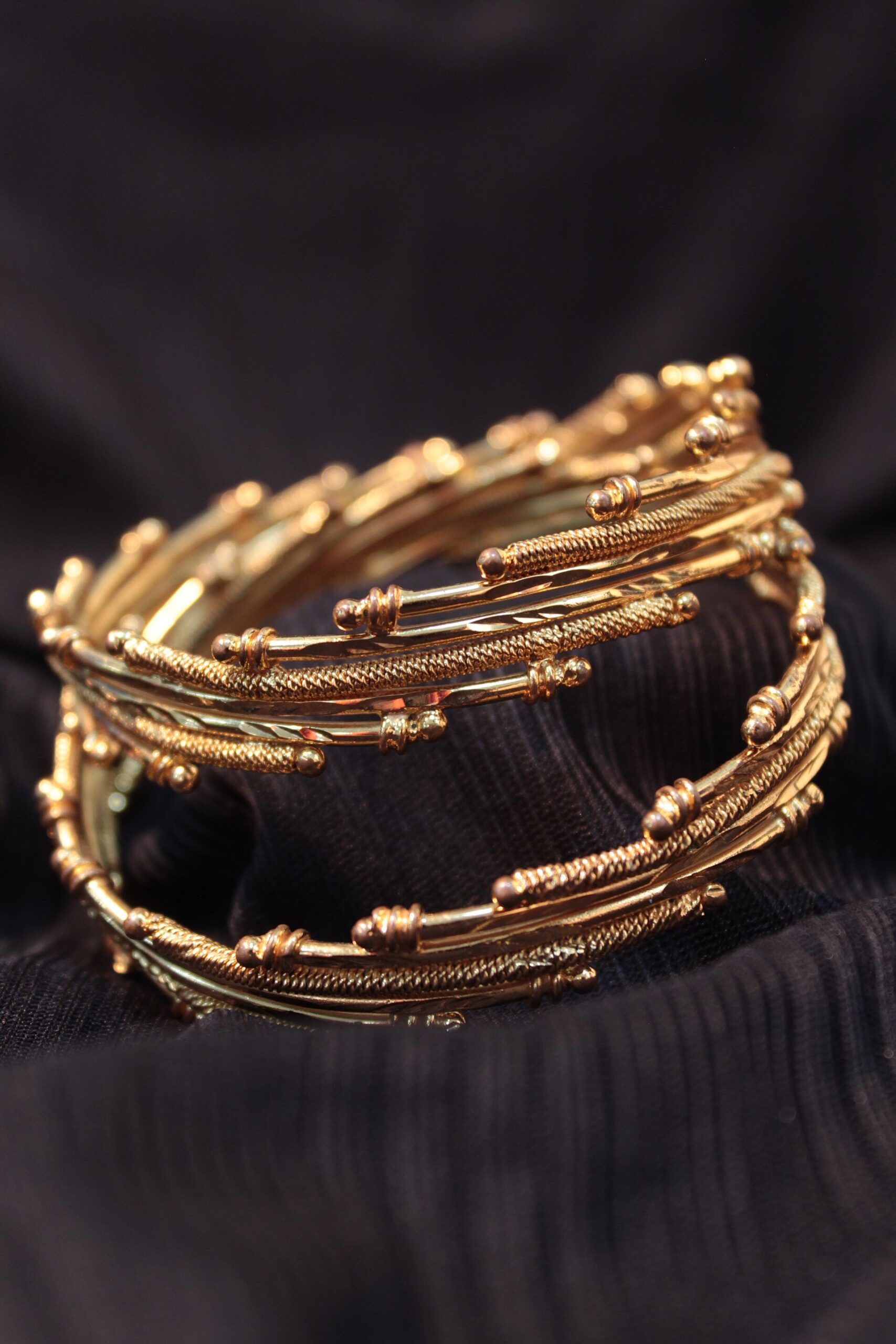 Gold-coloured bangles photographed close up, illustrating the need to verify materials and listing identity rather than relying on appearance alone