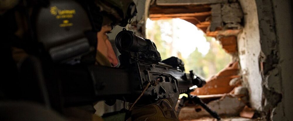 Italian soldier carrying a rifle equipped with an Elcan Specter DR optic
