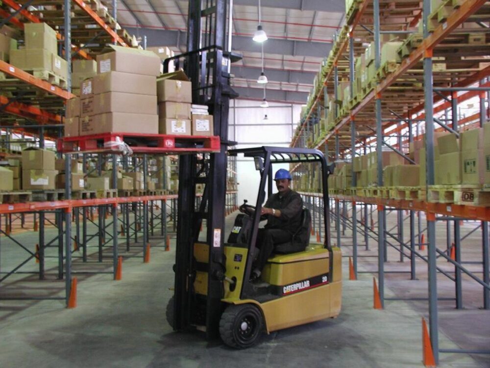 Counterbalance forklift in a warehouse, showing forks, mast and tyres clearly