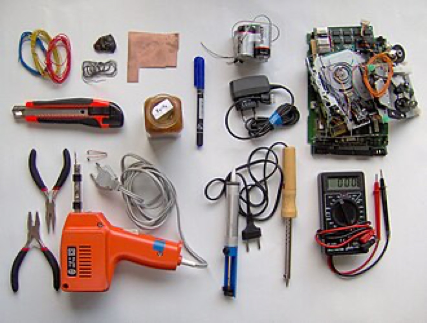 Assorted electronics tools and small hardware on a workbench