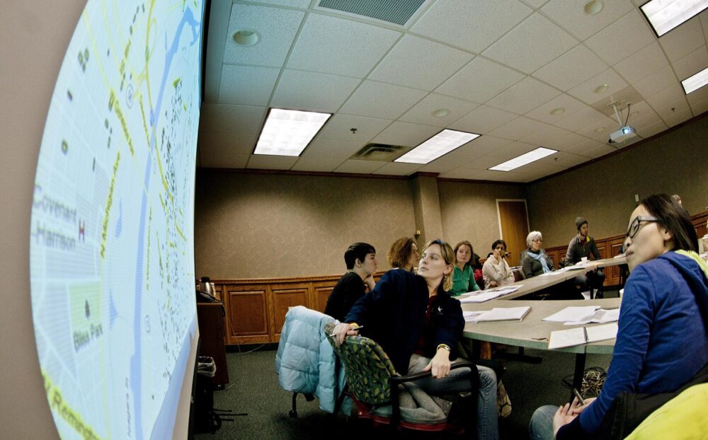 People reviewing posters and information at a session, symbolizing careful review of websites before trusting them