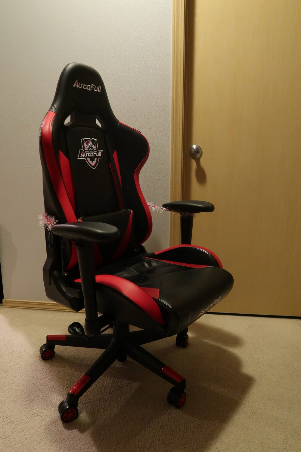 Black and red racing-style gaming chair in a home setup