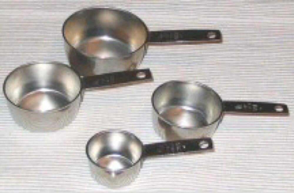 Set of plastic measuring cups in different sizes and colours
