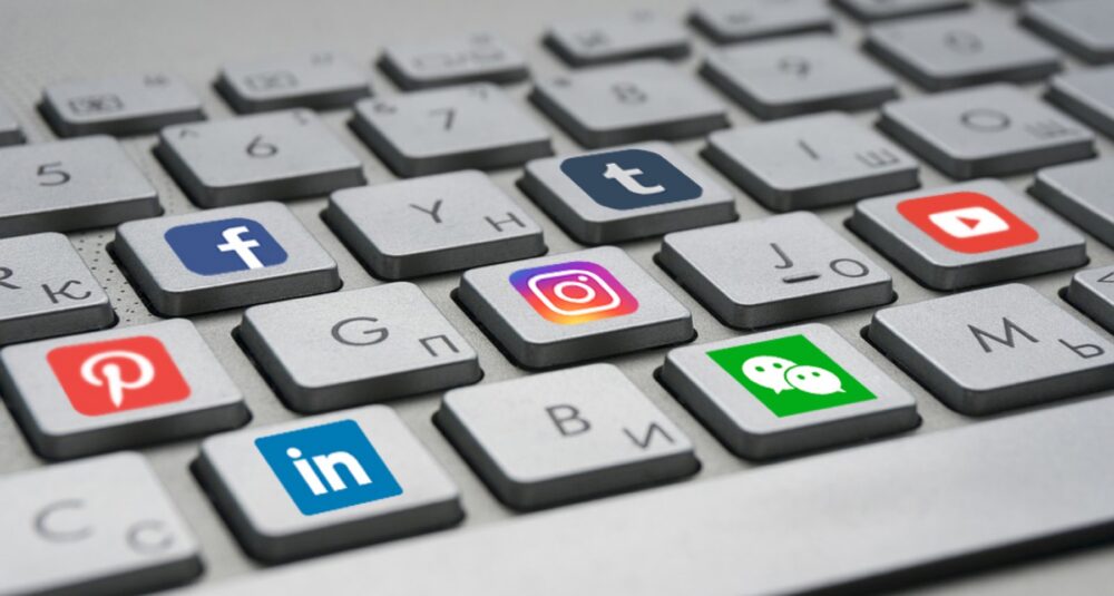 Illustration of social media icons surrounding a laptop symbolizing the overlap of social media and ecommerce