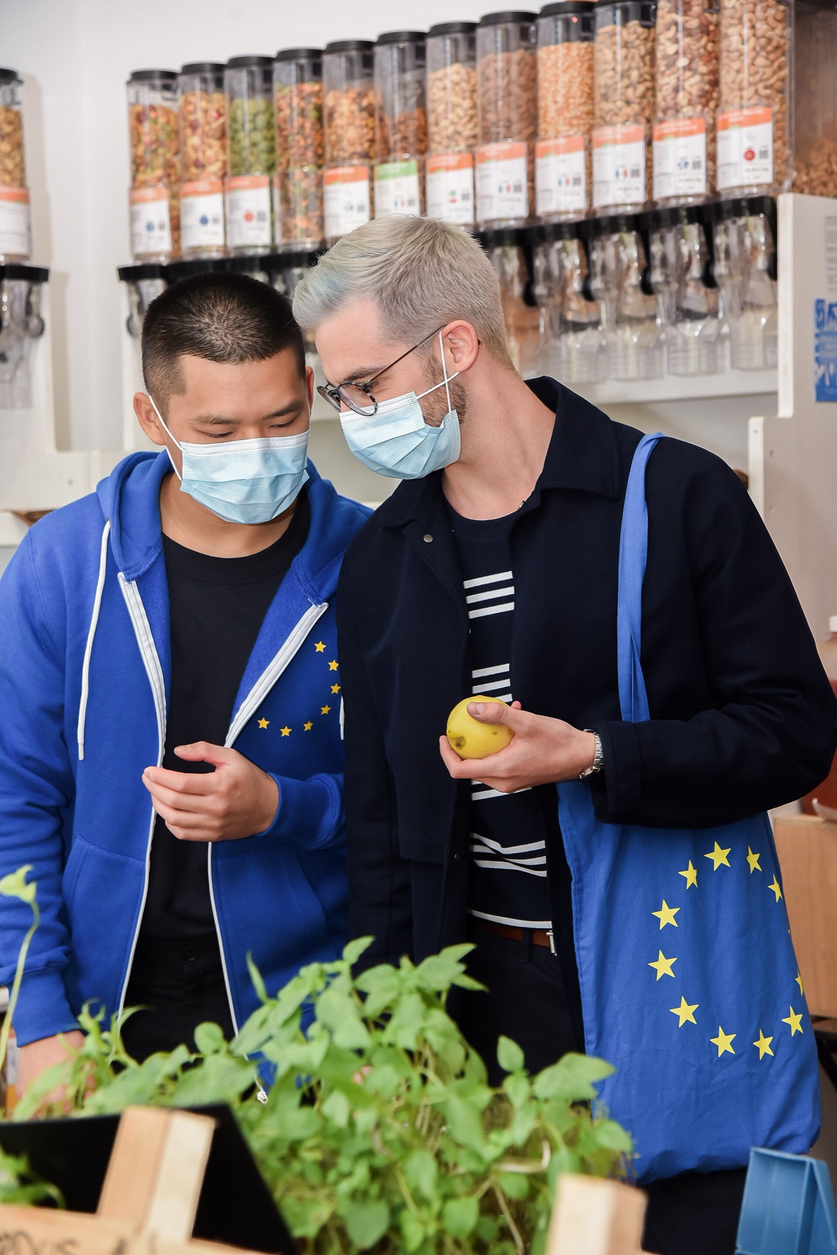 Shoppers comparing products in a bulk store aisle