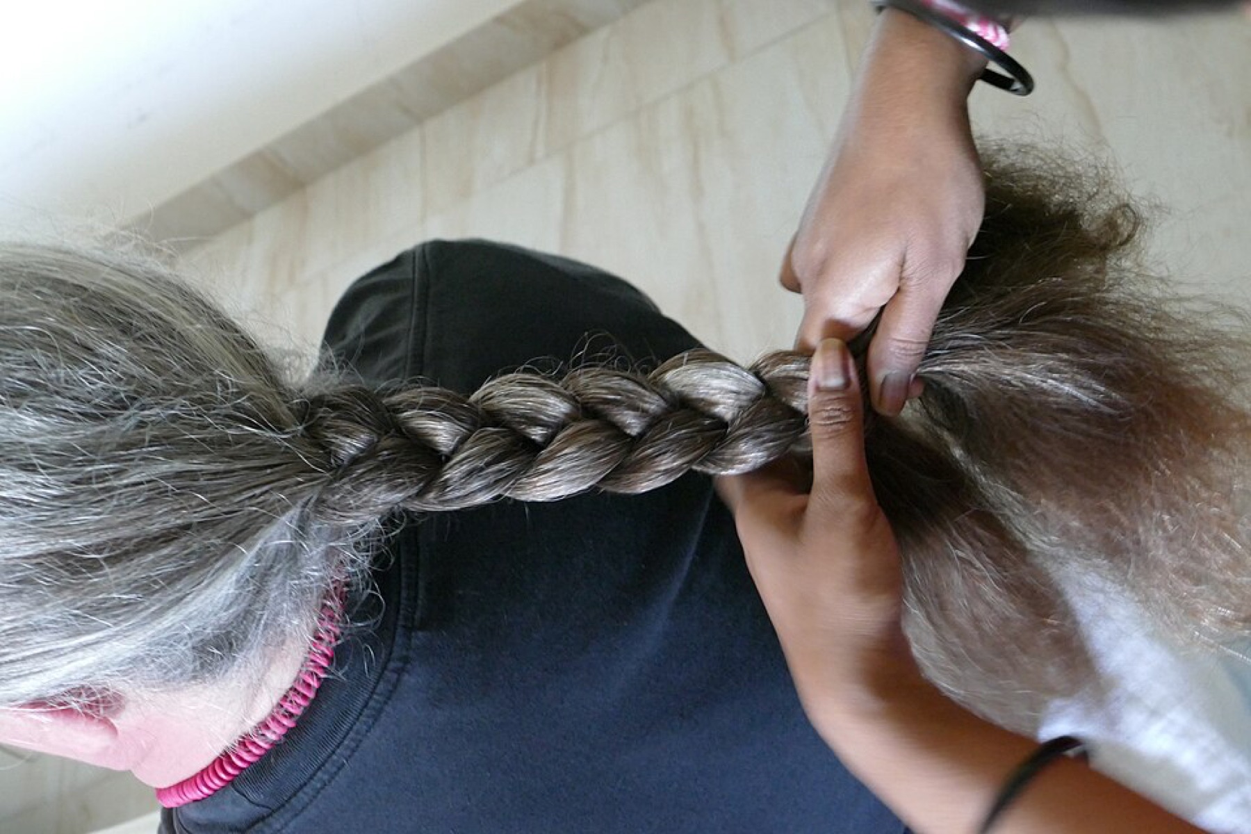 Stylist braiding client’s hair in a salon, illustrating bulk braiding hair in use
