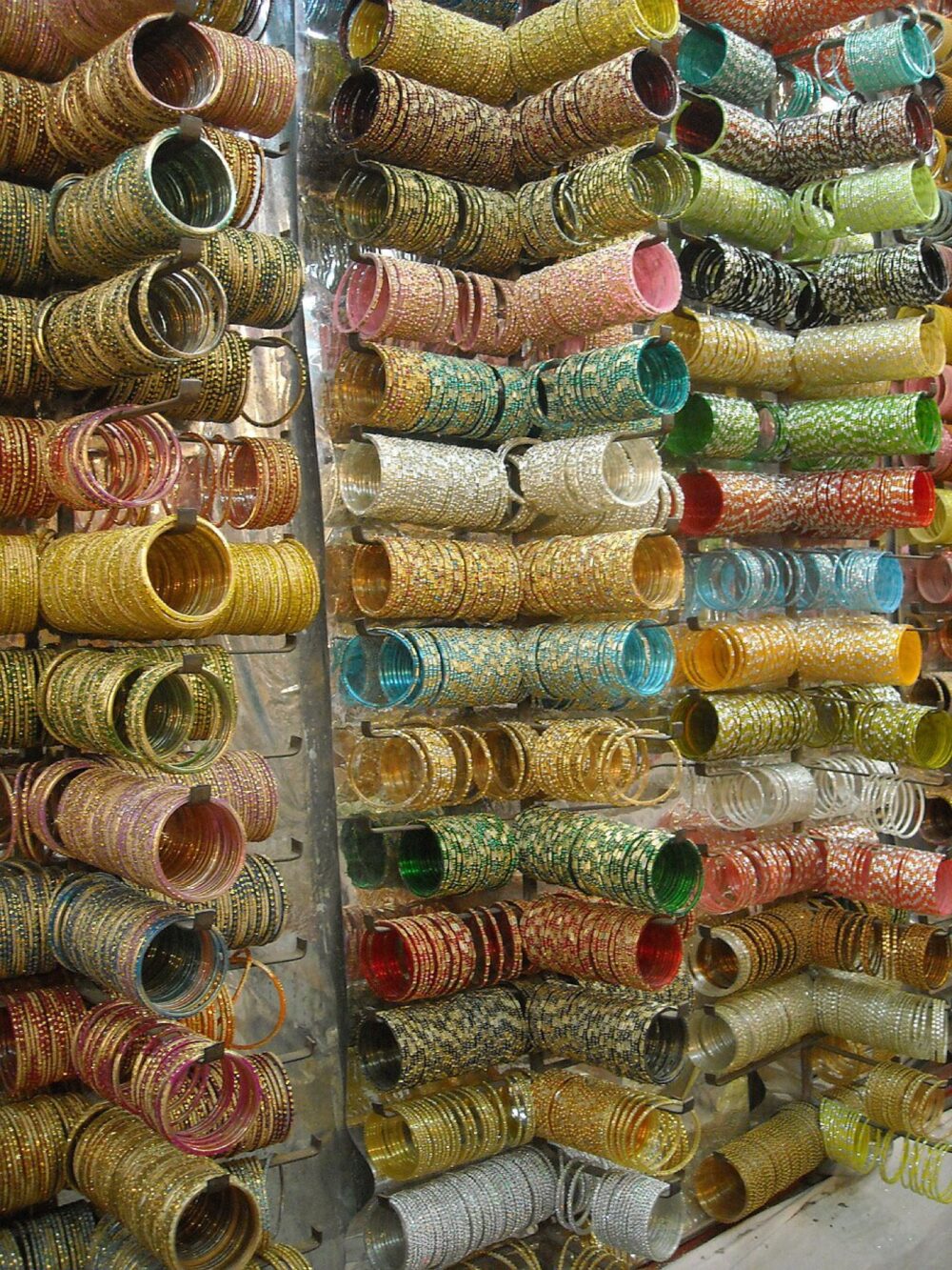 Assorted bangles displayed in bulk at a street stall, illustrating variety and volume in the wholesale bangle market.