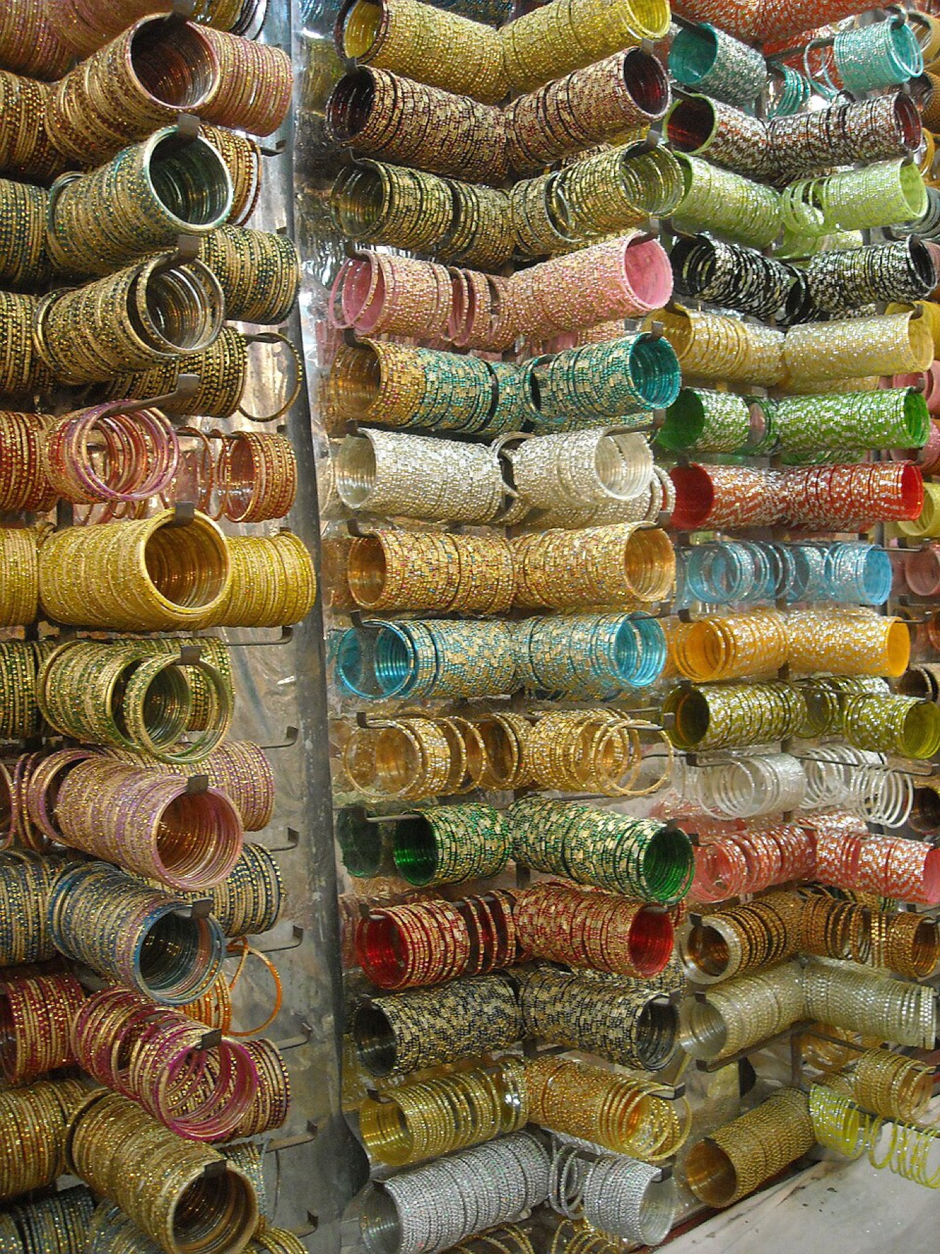 Assorted bangles displayed in bulk at a street stall, illustrating variety and volume in the wholesale bangle market.