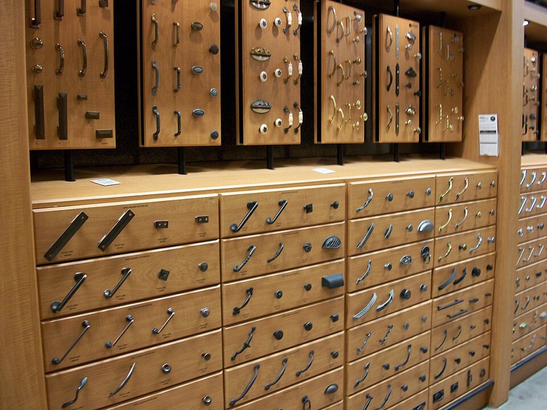 Assorted kitchen cabinet knobs and pulls mounted on display boards