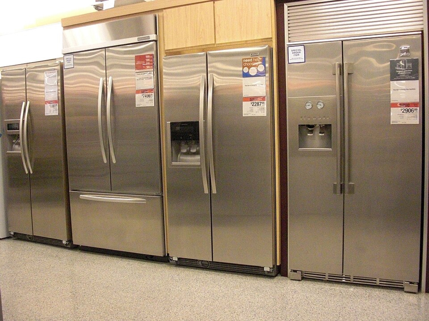 Row of household refrigerators in a retail showroom