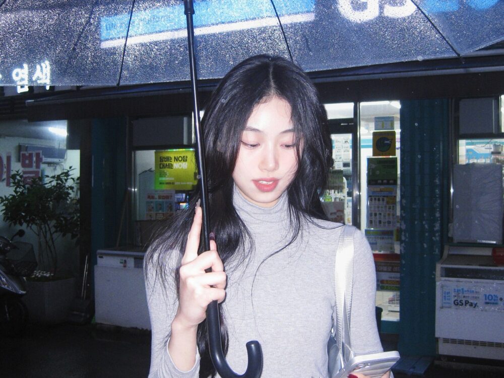 Person holding a transparent umbrella on a city street