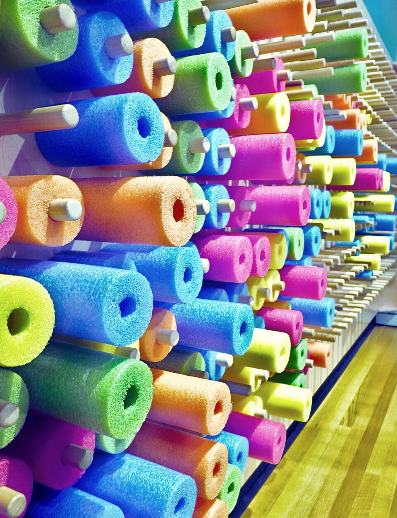 Colorful foam pool noodles arranged on a wall, illustrating typical consumer-grade noodles similar to DHgate bulk listings.