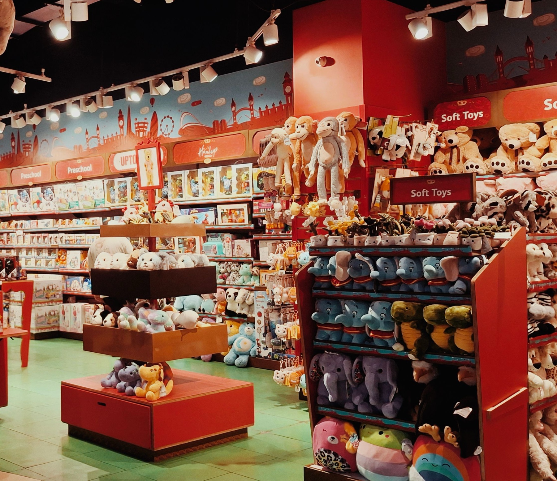 Person browsing toys online on a laptop with colourful toys in the background