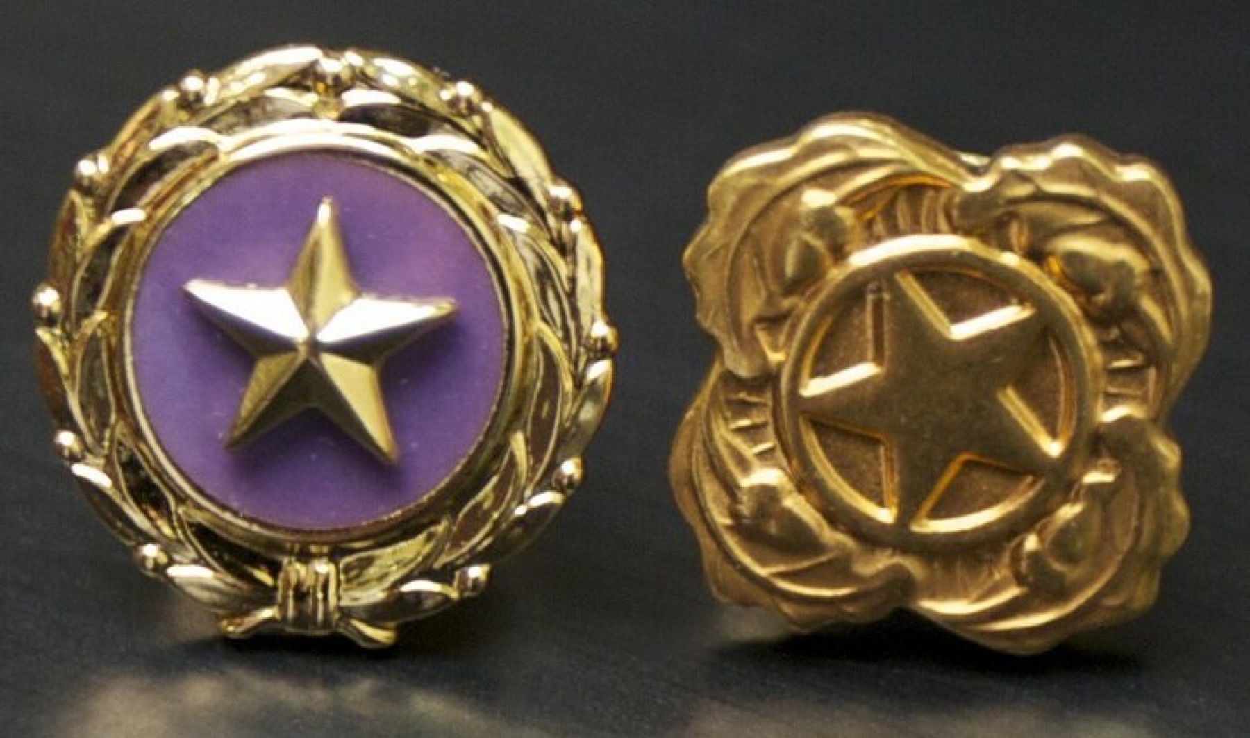 Gold star lapel pins arranged in a row