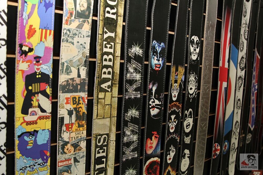 Assorted guitar straps hanging on display, illustrating variety of materials and designs