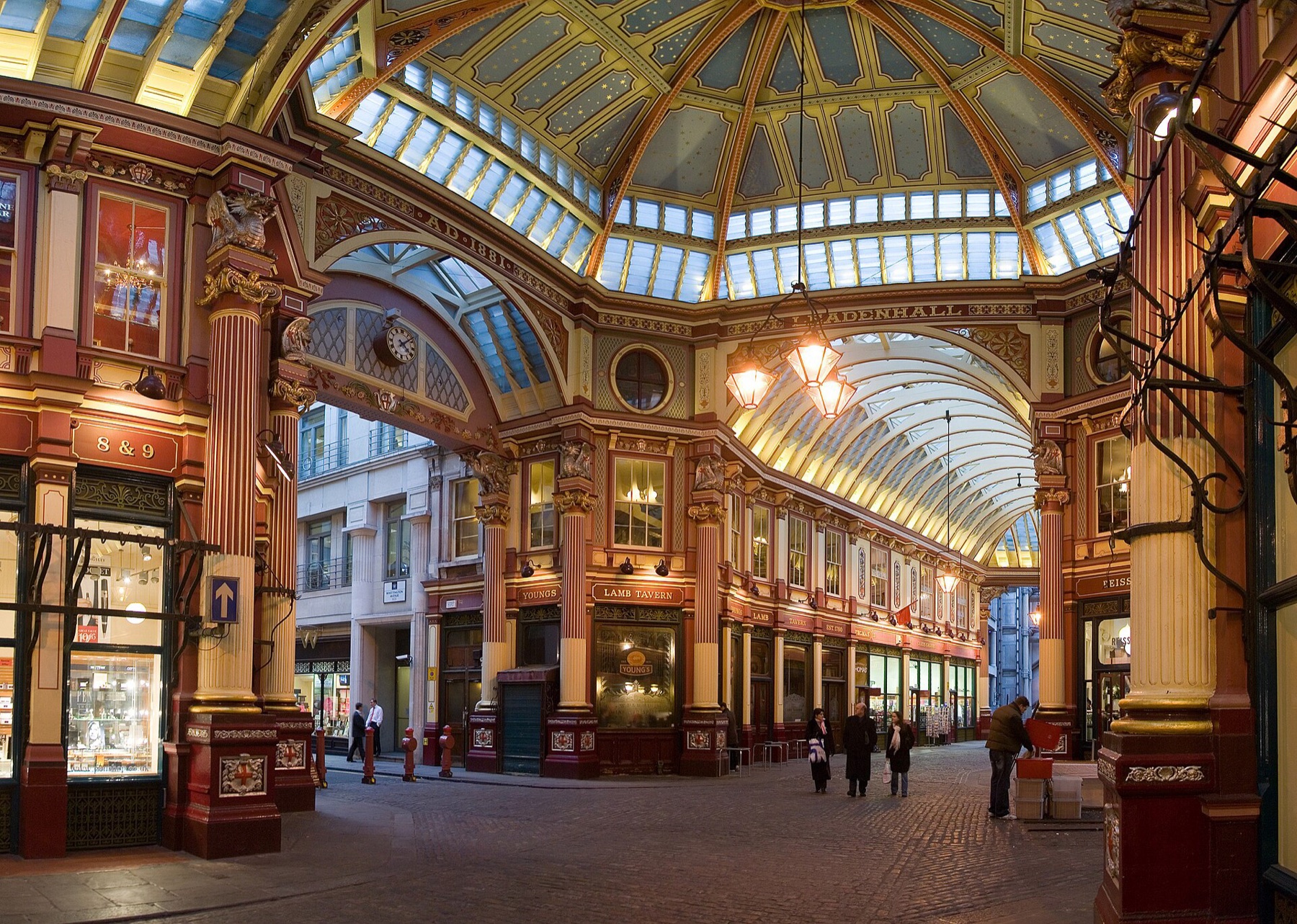 Covered indoor market arcade with shops and people walking