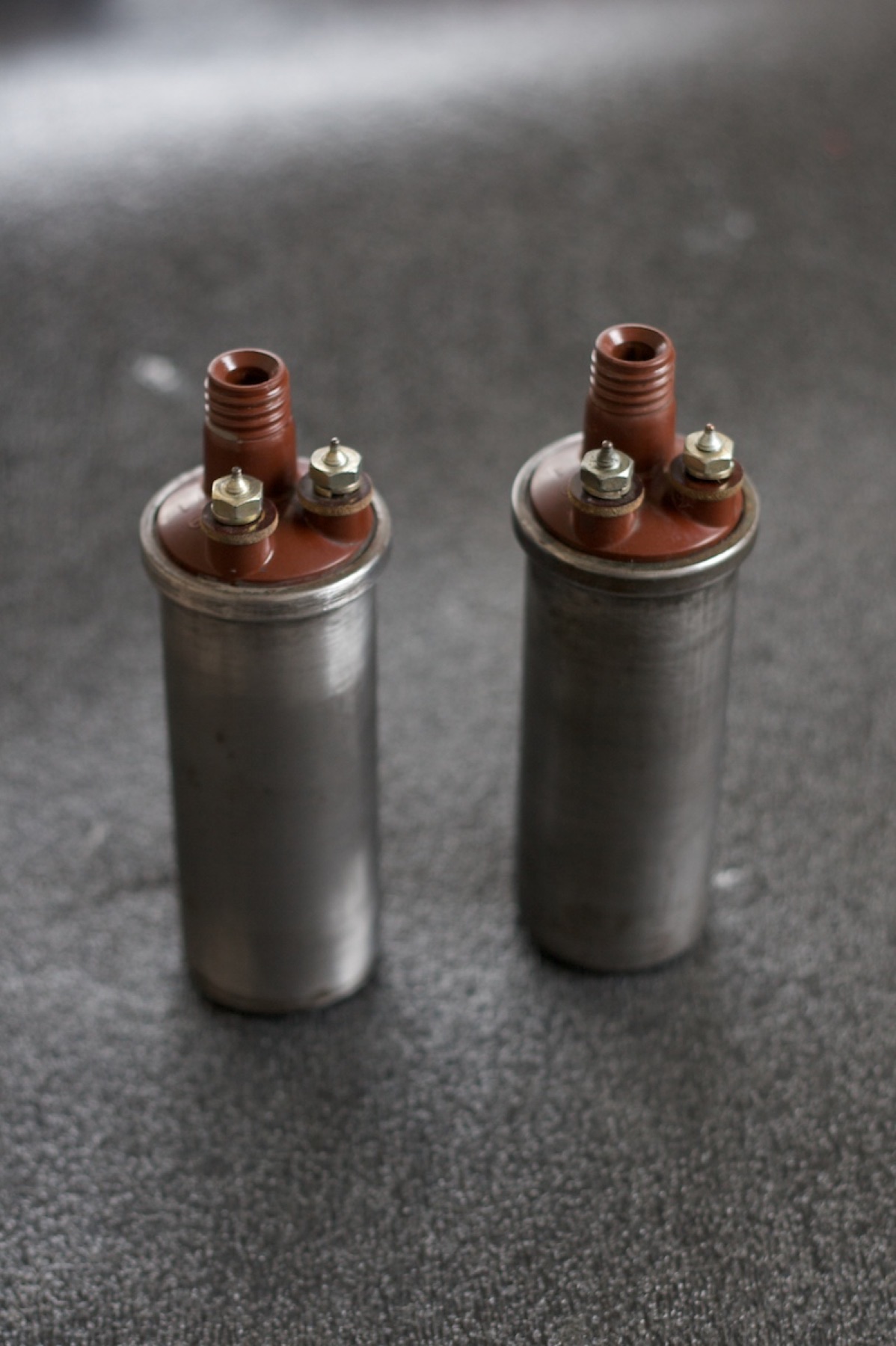 Close-up of several automotive ignition coils laid out on a workbench