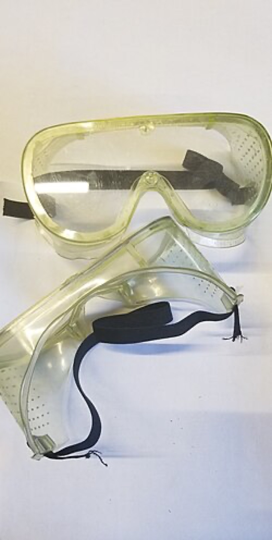 Black frame safety goggles resting on a bench