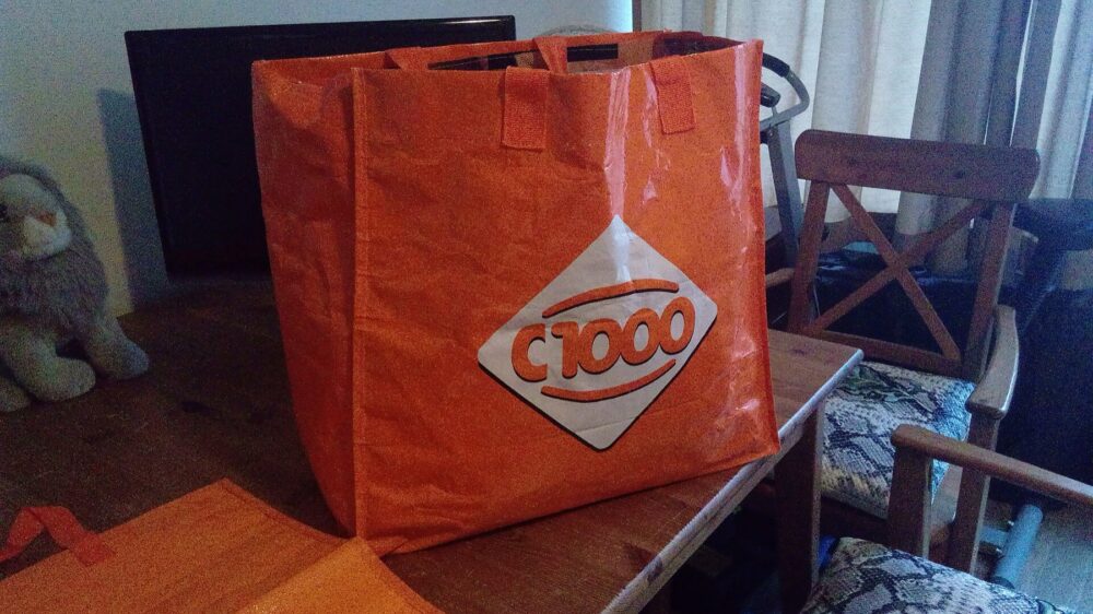 Large shopping bags stacked in a supermarket aisle