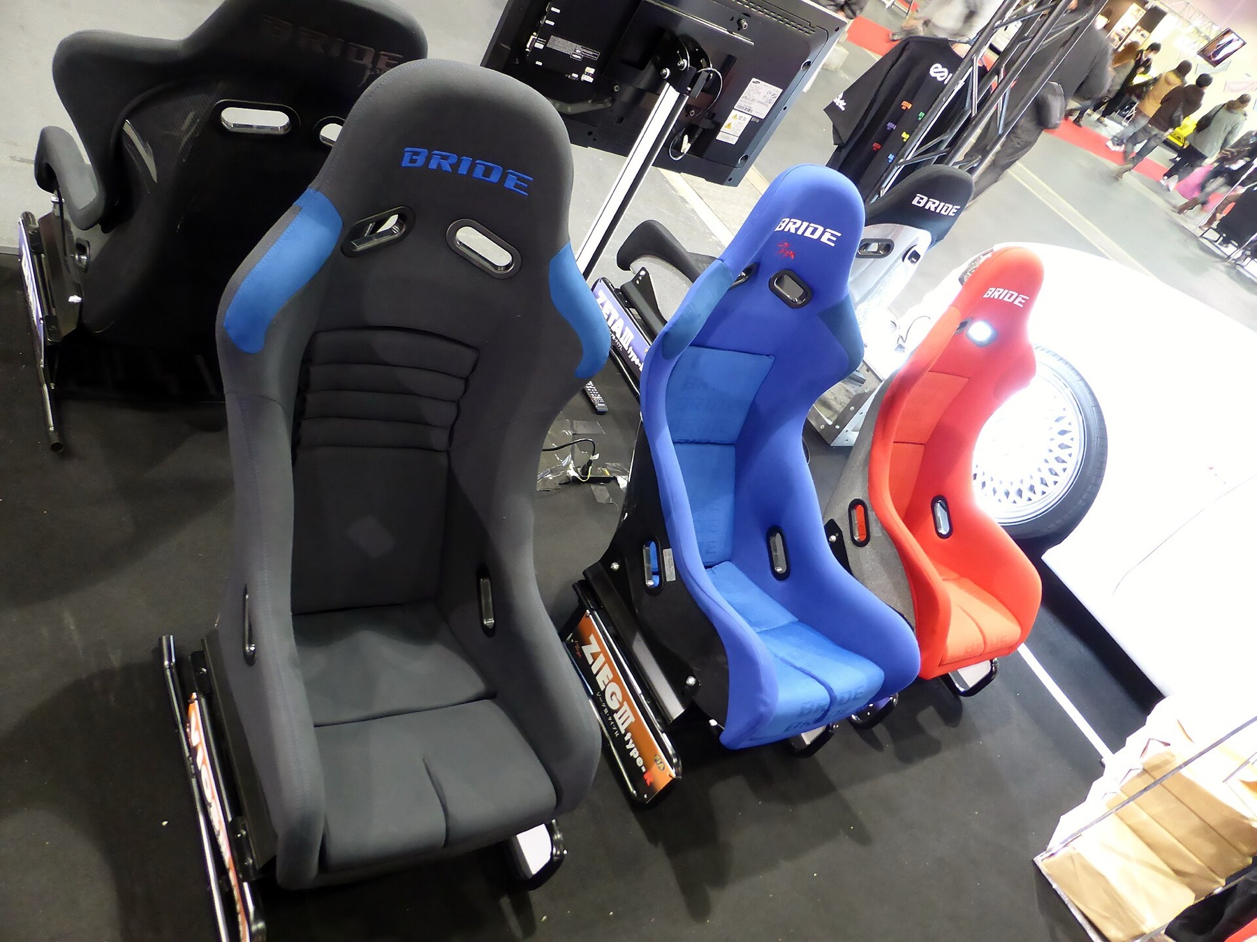 Pair of BRIDE-brand bucket racing seats displayed at an auto show.