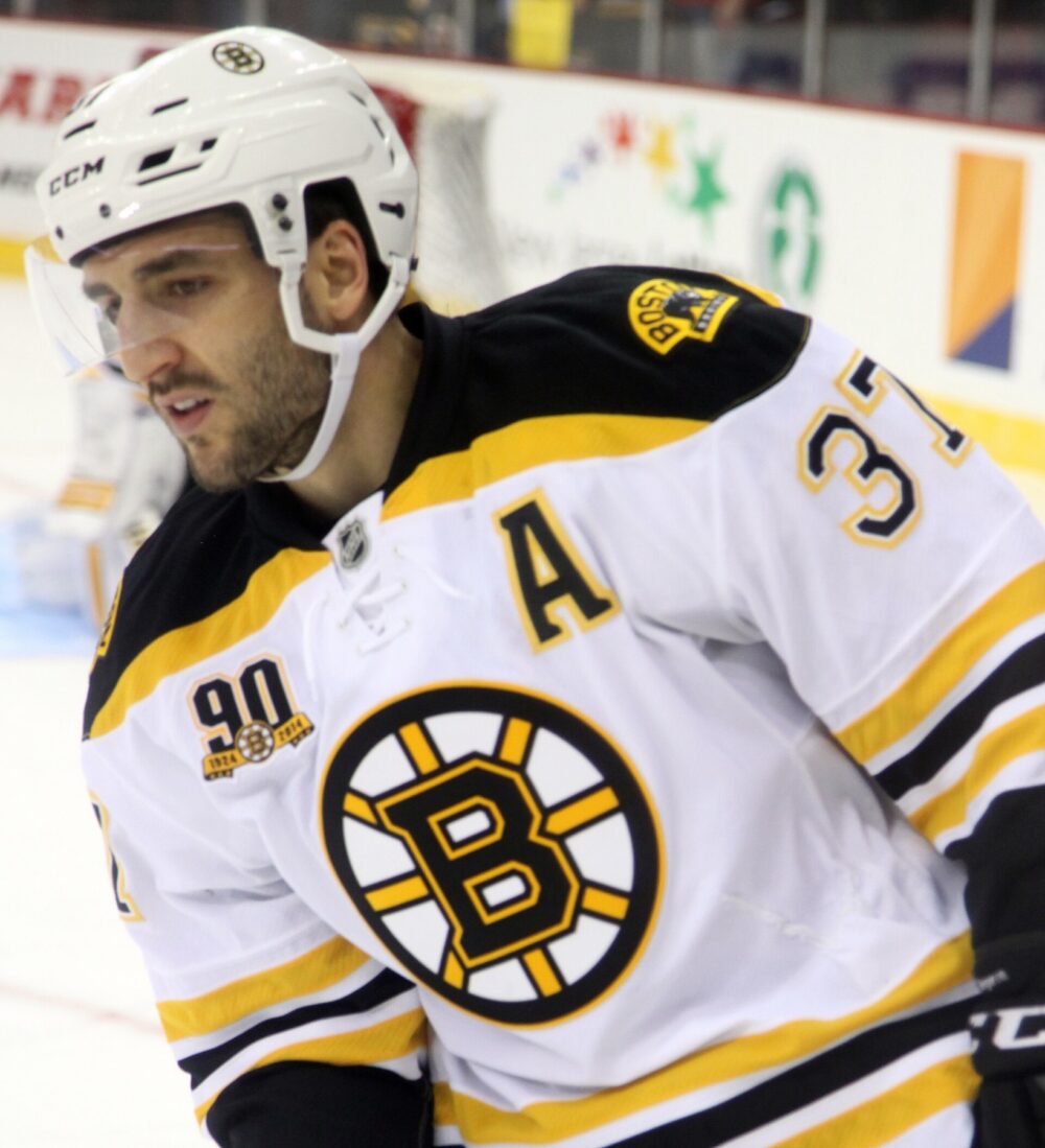 Bruins player in black and gold jersey during an NHL game, illustrating the base style many Happy Gilmore jerseys mimic