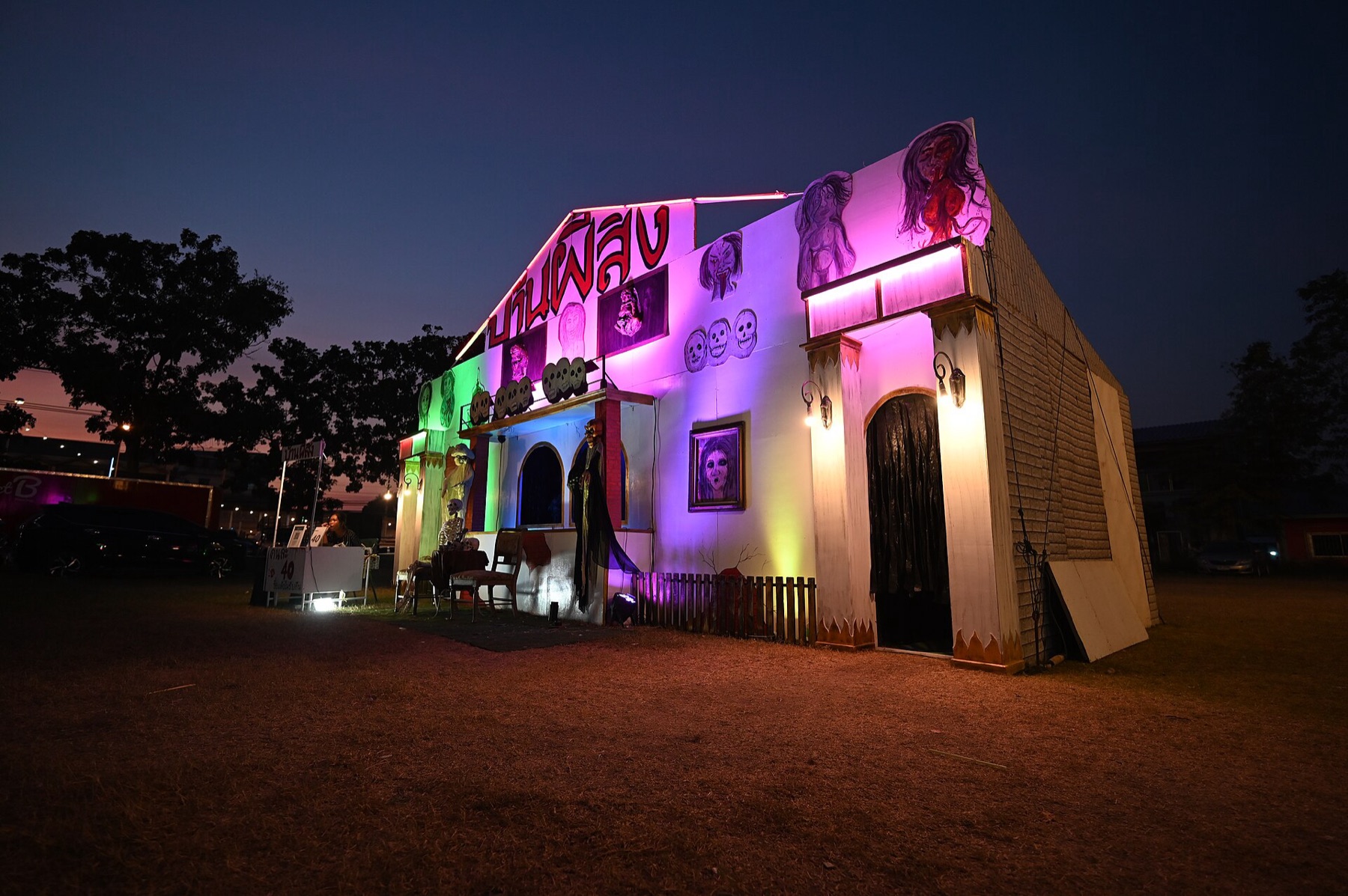 Colorful neon-lit carnival funhouse exterior at dusk