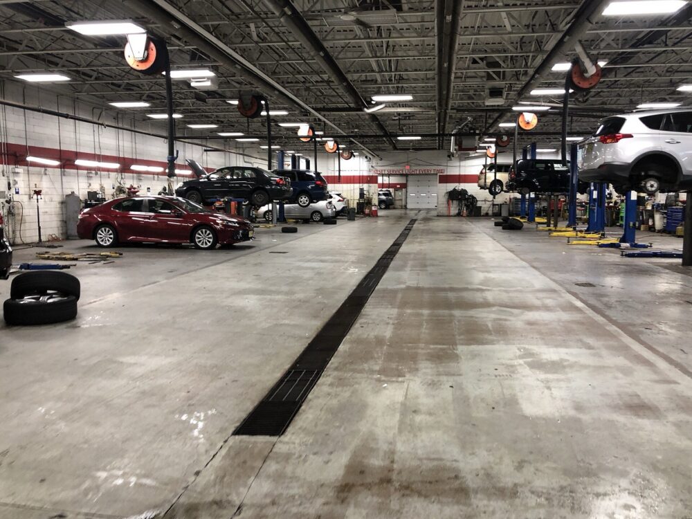 Interior of a Toyota repair shop with vehicles on lifts and service equipment