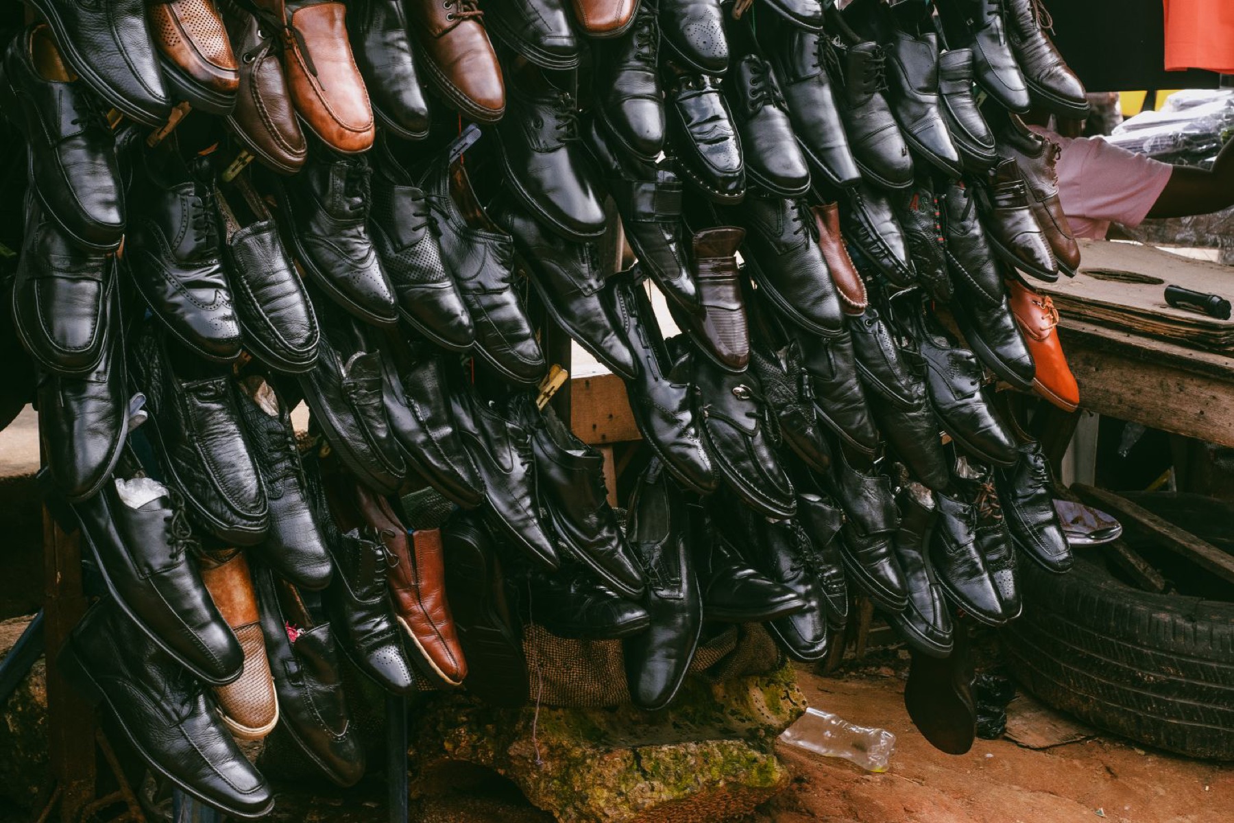 Display of assorted leather shoes in a busy market stall, representing multiple potential shoe suppliers