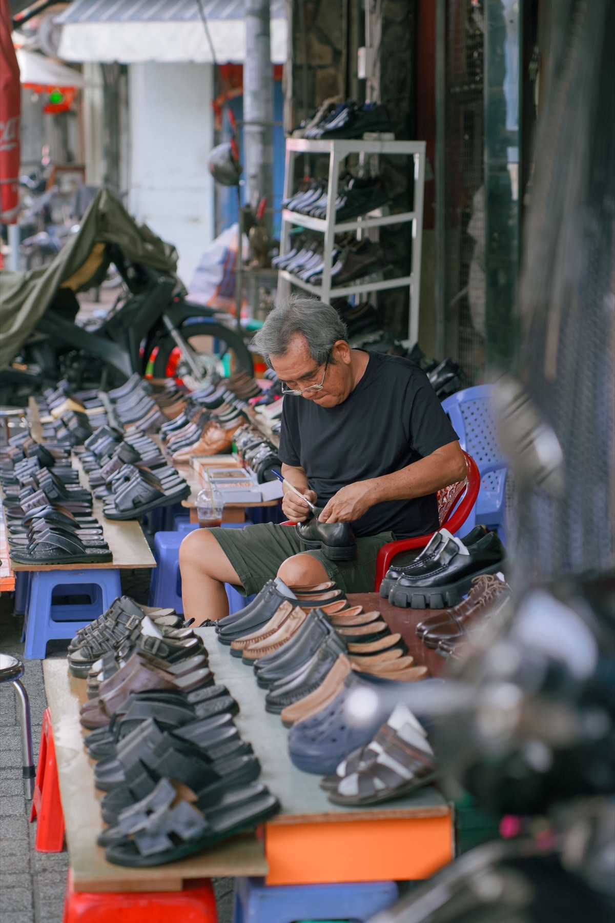 Retailer reviewing suppliers on a laptop while looking at shoe samples