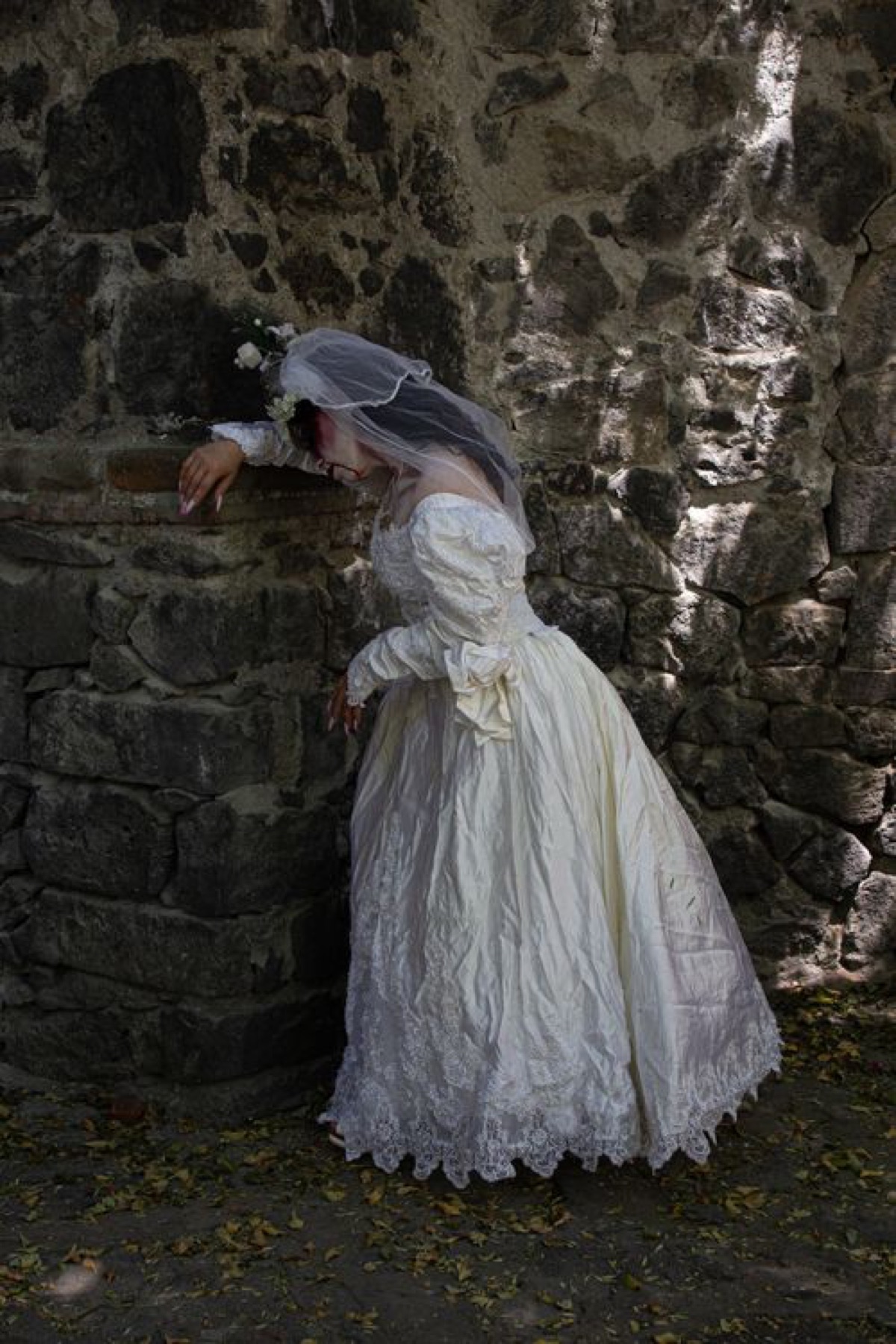 Bride in long-sleeved vintage-style wedding dress holding bouquet outside a church