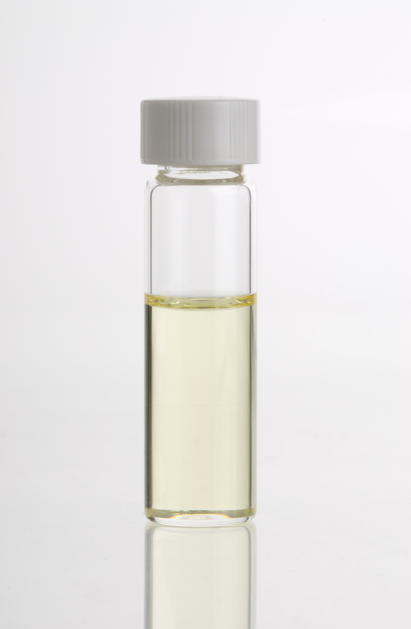Small bottle of lavender essential oil next to dried lavender flowers
