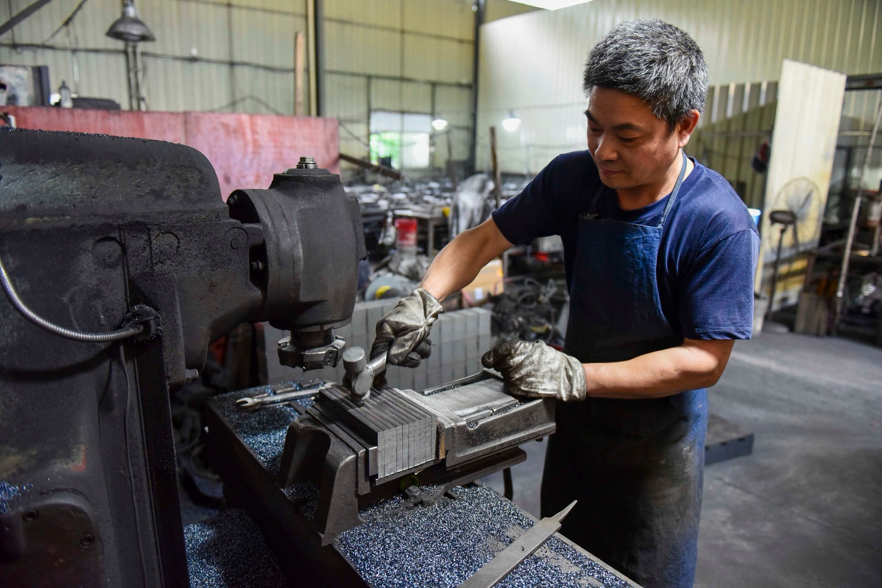Worker in Asian workshop representing factory-level production