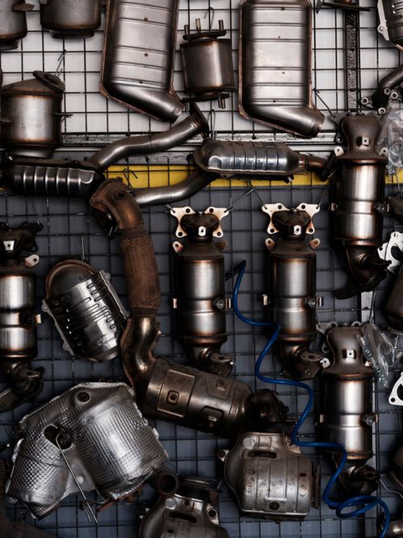 Shelves of car exhaust and metal parts in a workshop, illustrating organized auto parts resources