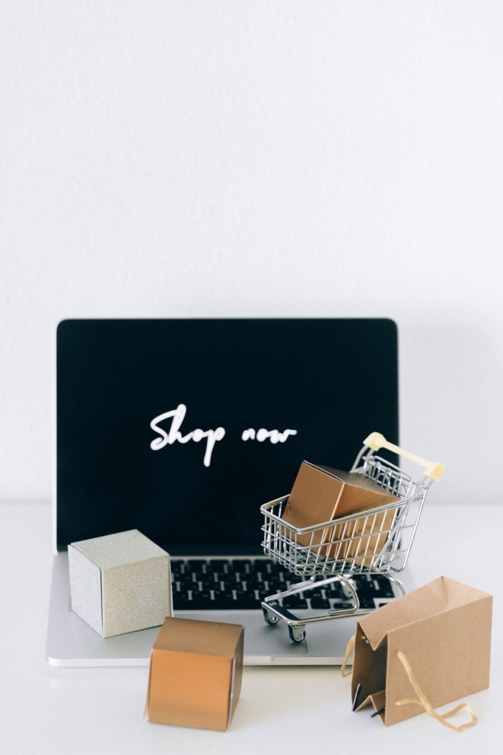 Laptop, shopping cart and parcels representing an e-commerce sourcing workflow