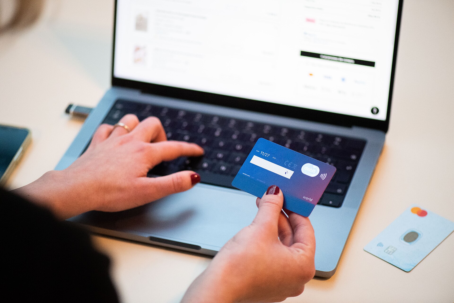 A shopper using a bank card during an online purchase, illustrating that cashback starts with an eligible checkout transaction