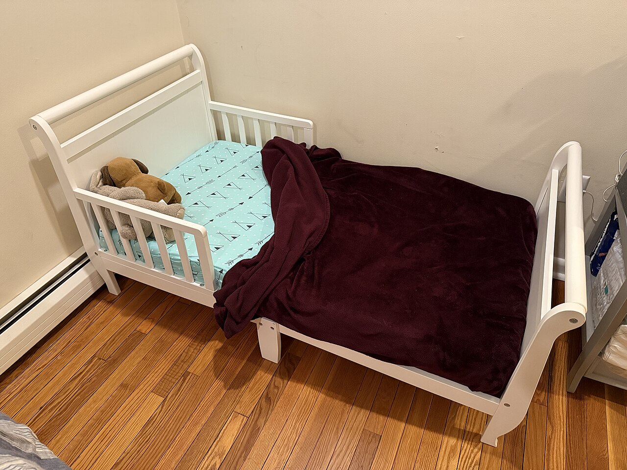 A toddler bed with raised side panels that help illustrate where fall-prevention barriers sit relative to the mattress.