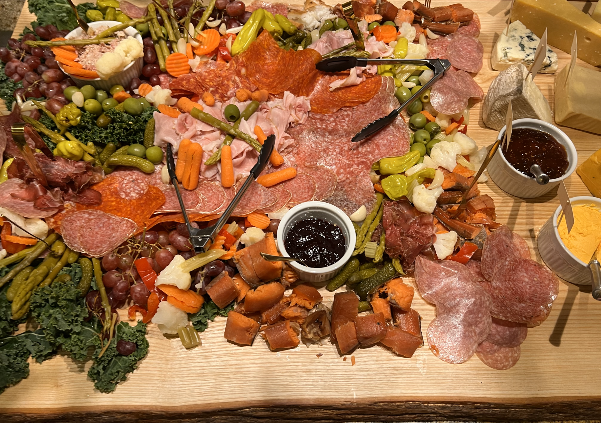 A wooden charcuterie board arranged with cheese, meats, peppers, and jam, illustrating the food-contact use discussed in the sourcing guide.