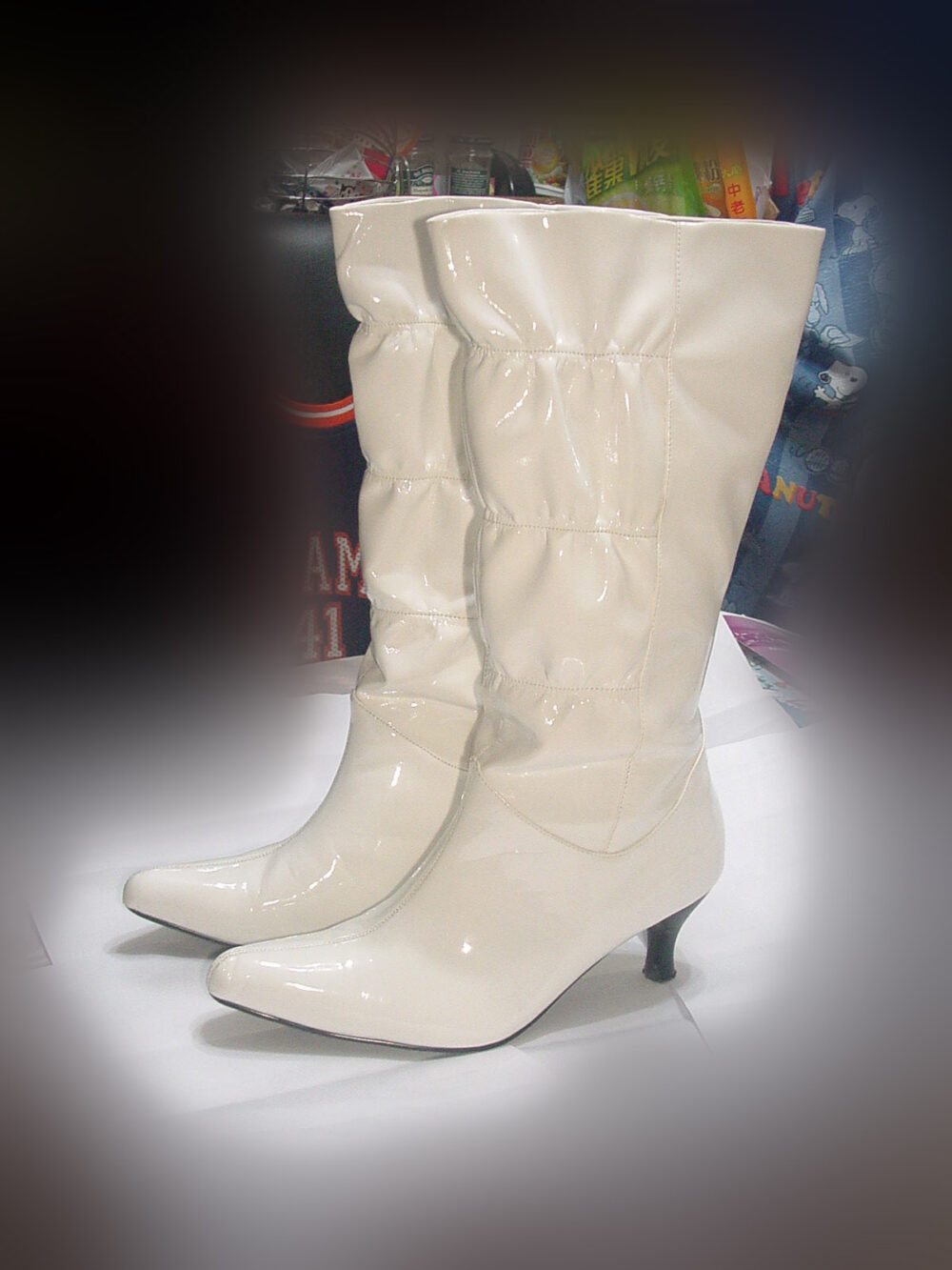 A pair of white leather knee-high boots with slim heels, illustrating the fashion silhouette discussed in the article.