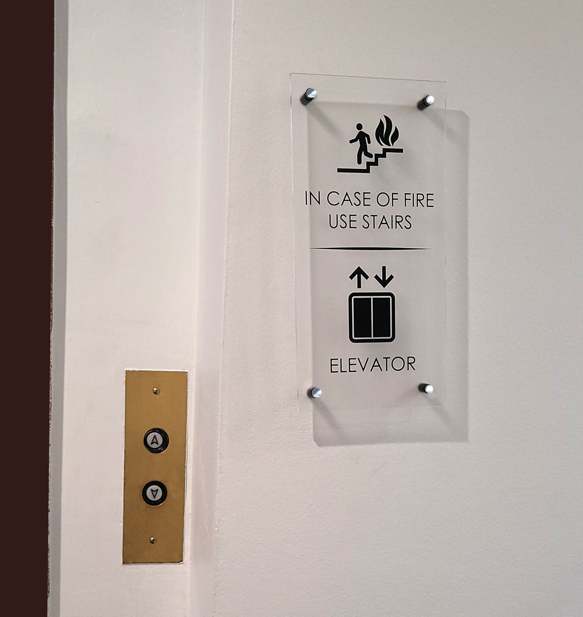 A clear acrylic wall display illustrating printed graphics, drilled corners, and standoff mounting for custom fixture comparisons