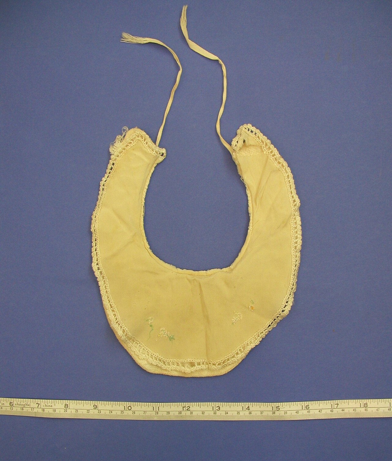 Yellow cloth baby bib with embroidered front and crocheted edge