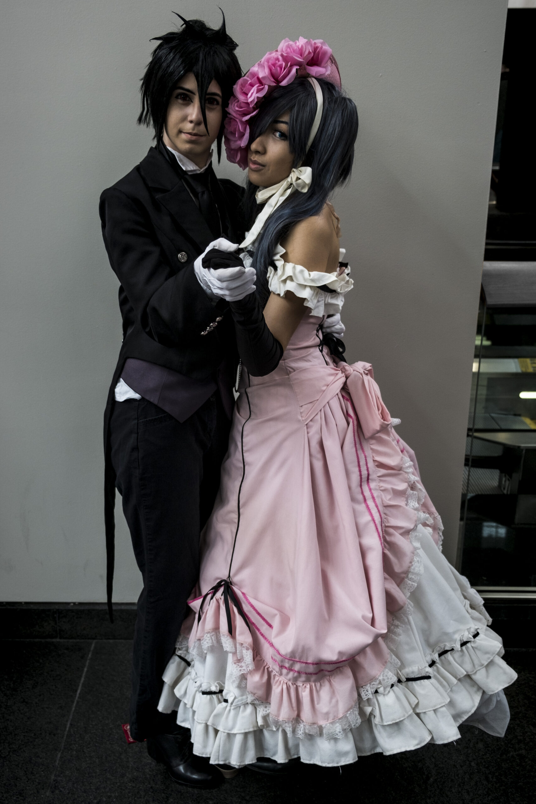 Cosplayers dressed as Sebastian Michaelis and Ciel Phantomhive from Black Butler, illustrating the characters and gothic aesthetic referenced by collectible figures