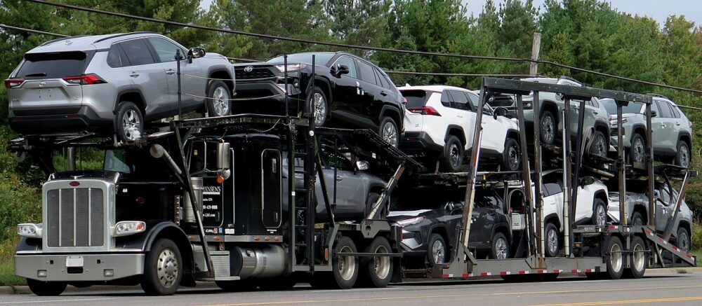 Black car-hauler truck configured to transport multiple vehicles