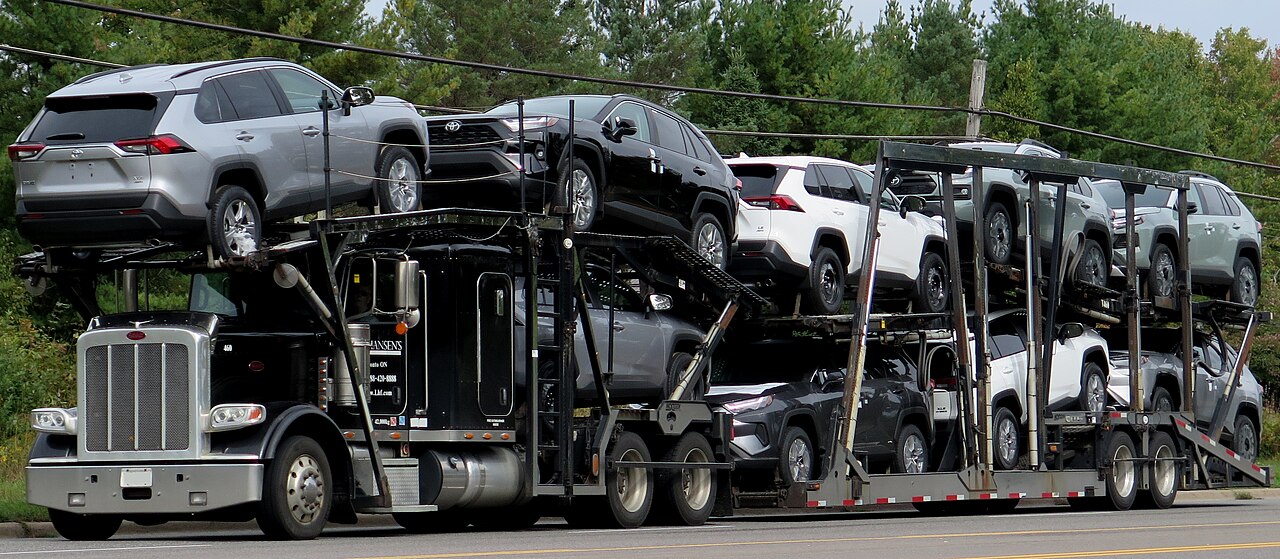 Black car-hauler truck configured to transport multiple vehicles