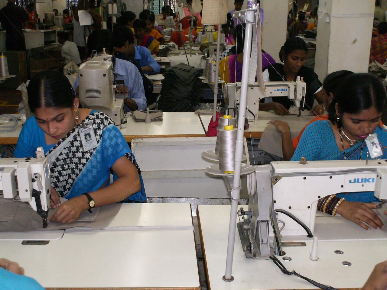 Workers operating sewing machines in a clothing factory
