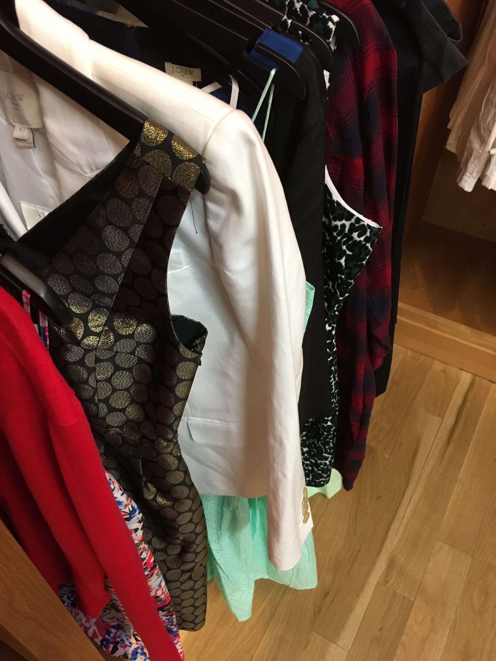 Multiple apparel racks in a retail setting, illustrating how assortment breadth changes across shopping channels