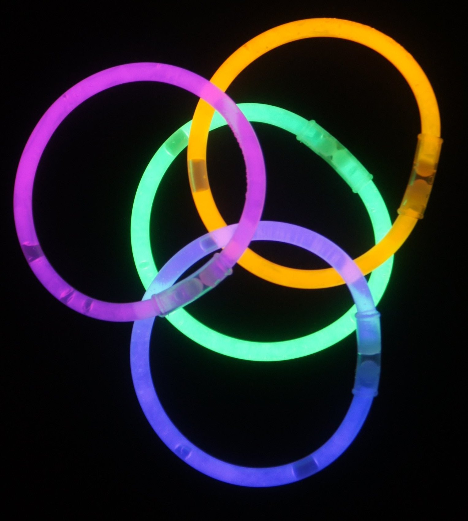 Various colored glow sticks arranged as rings on a black background